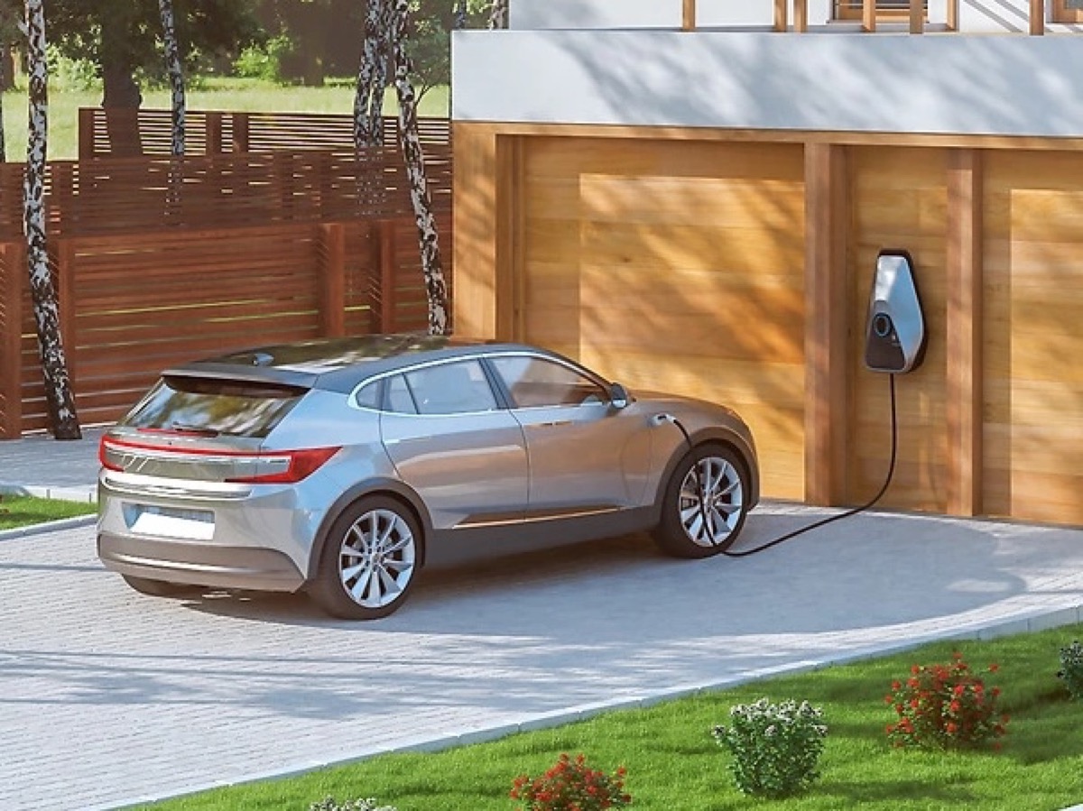 Wallbox-Ladestation an einer Hauswand, E-Auto lädt