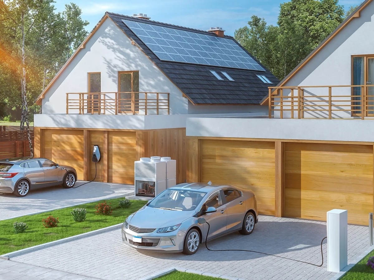 Haus mit Photovoltaikanlage auf dem Dach, zwei ladende E-Autos